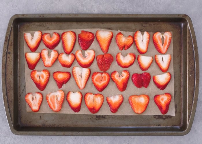 tray with strawberry slices into a food dehydrator machine Stock