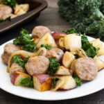 Sausage, potatoes, onion, and kale on a plate